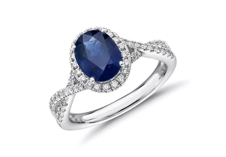 A blue sapphire engagement ring set in diamond studded twisted setting
